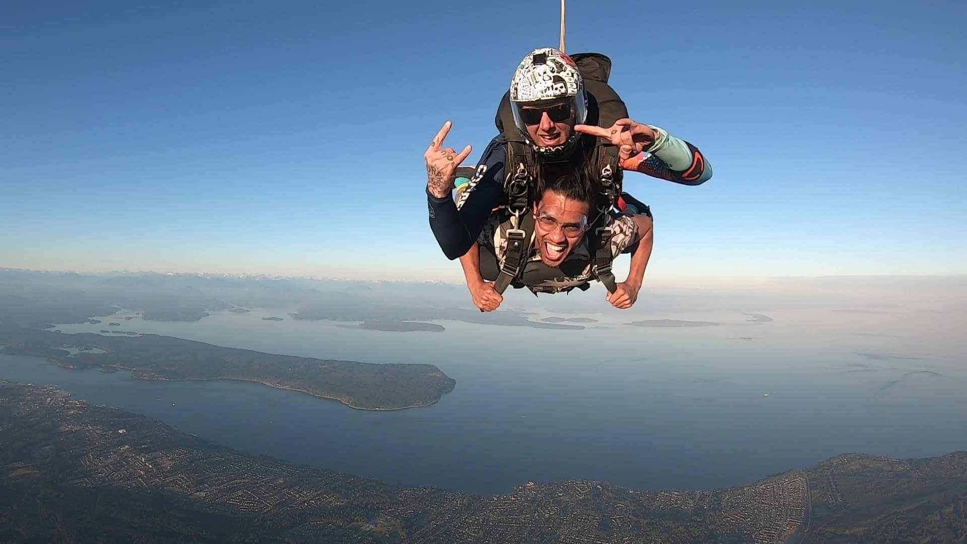 2 men during a tandem skydive with Campbell River in the background