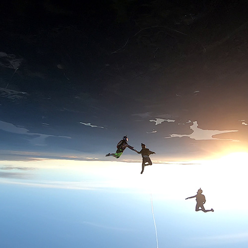 Licensed skydivers in the sky with a sunet