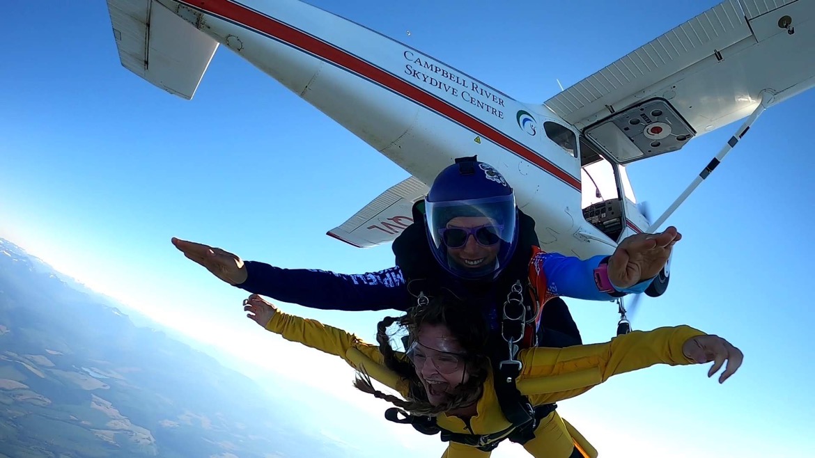 Tandem skydive with a plane in the background